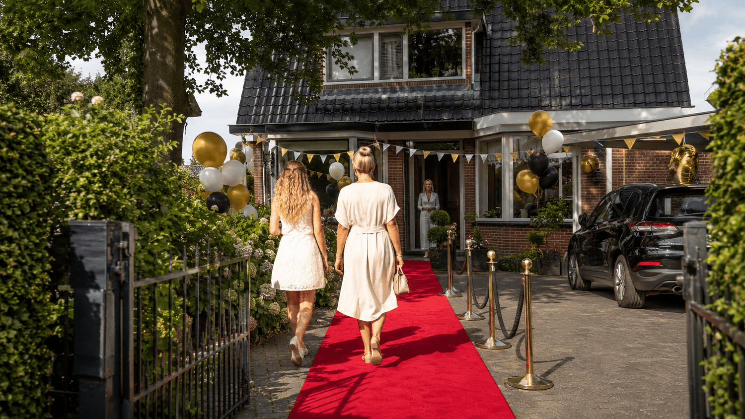 Rode loper met afzetpalen bij de feestelijke entree van een slagingsfeest