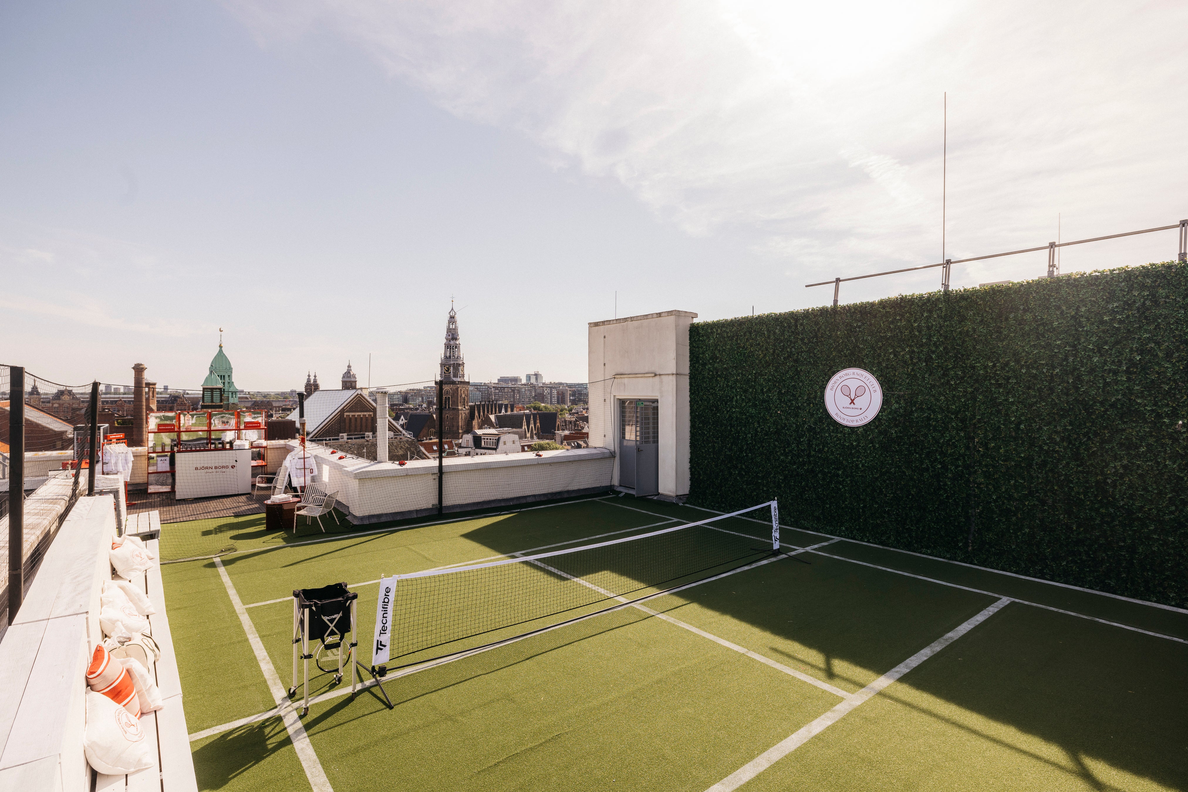 Rooftop tennisbaan van kunstgras met kunsthaag-wand op het dak van De Bijenkorf Amsterdam tijdens de Bjorn Borg Rooftop Rally. Foto: Kirsten van Santen